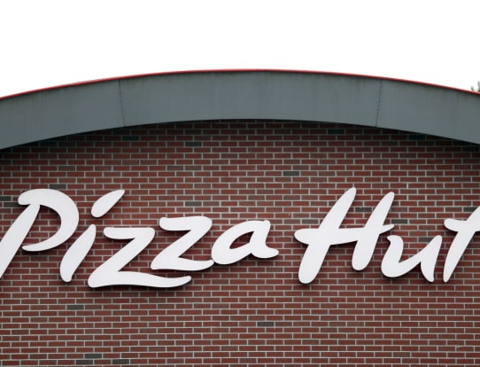 The Pizza Hut logo displayed on a brick building facade.